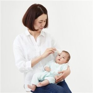 お母さんが非接触で赤ちゃんの検温している画像